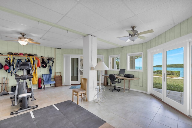 interior space with french doors, ceiling fan, and a drop ceiling