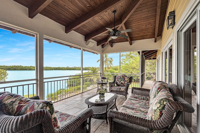 sunroom with vaulted ceiling with beams, wood ceiling, ceiling fan, and a water view