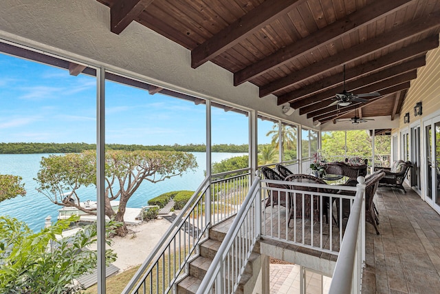 sunroom / solarium with ceiling fan, a water view, vaulted ceiling with beams, and wood ceiling