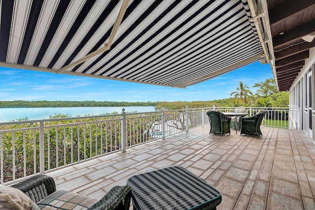 view of patio / terrace with a balcony and a water view