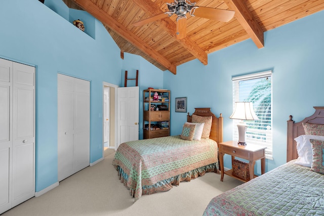 bedroom with two closets, light colored carpet, wooden ceiling, and beam ceiling