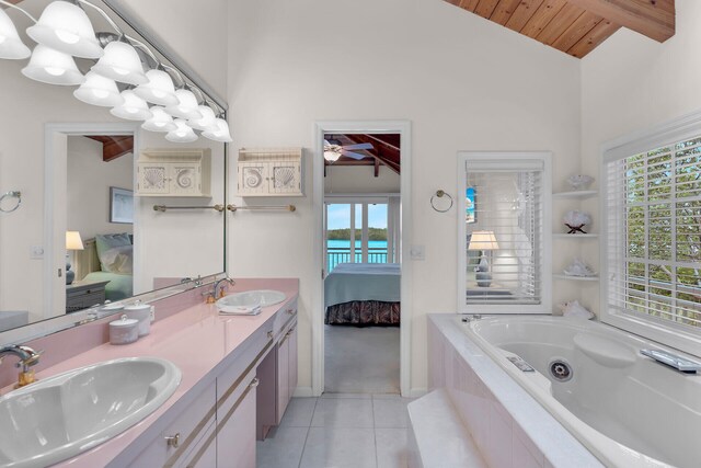 bathroom with vaulted ceiling with beams, vanity, a relaxing tiled tub, wooden ceiling, and tile patterned floors