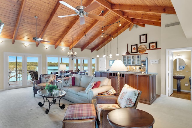 living room featuring a wealth of natural light, ceiling fan with notable chandelier, light carpet, and high vaulted ceiling