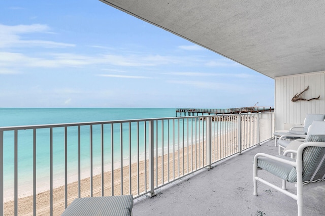 balcony featuring a water view and a view of the beach