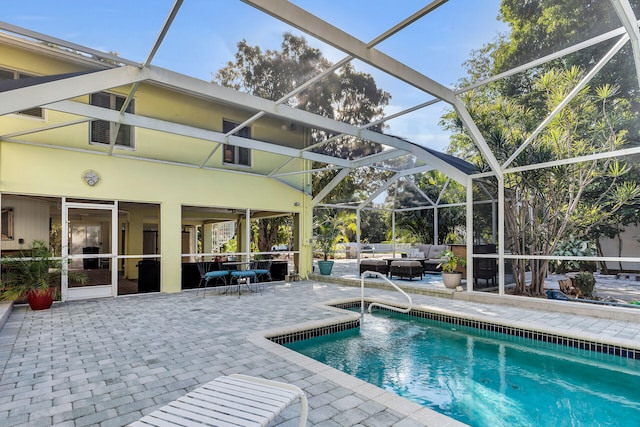 view of pool with an outdoor living space, a lanai, and a patio area