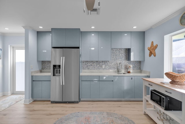 kitchen featuring stainless steel refrigerator with ice dispenser, sink, gray cabinetry, and ornamental molding