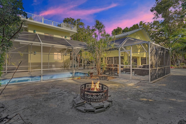 exterior space with a fire pit, a patio area, and glass enclosure