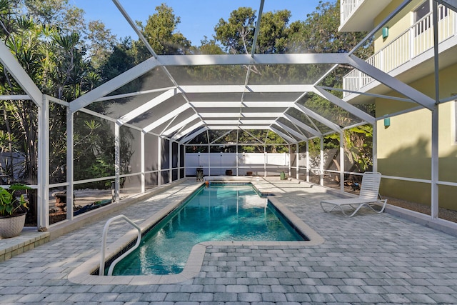 view of pool with a patio and glass enclosure