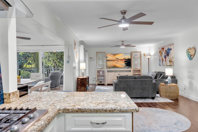 kitchen with dark hardwood / wood-style flooring, ornamental molding, stainless steel gas cooktop, and white cabinets