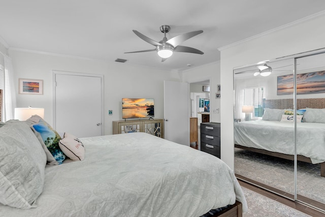 bedroom with crown molding, dark hardwood / wood-style floors, ceiling fan, and a closet