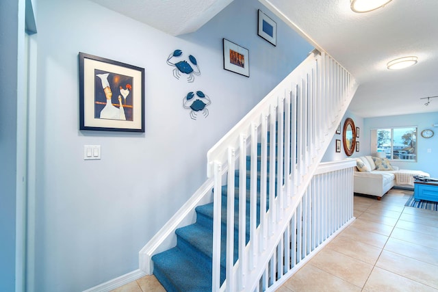 95 Coco Plum Dr Unit 4C, Marathon, FL 33050 - stairway with tile patterned floors, baseboards, and a textured ceiling