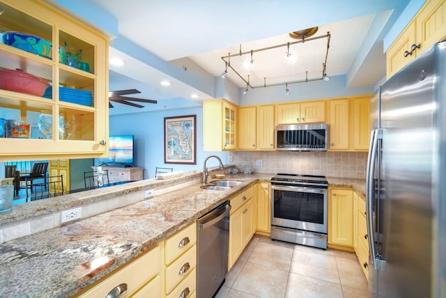 95 Coco Plum Dr Unit 4C, Marathon, FL 33050 - kitchen with glass insert cabinets, light tile patterned floors, a sink, appliances with stainless steel finishes, and backsplash