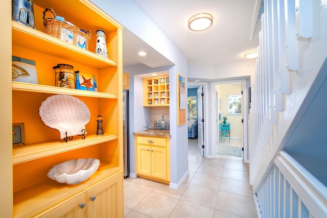95 Coco Plum Dr Unit 4C, Marathon, FL 33050 - kitchen with light tile patterned floors, backsplash, freestanding refrigerator, and open shelves