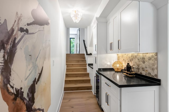 stairs with wine cooler and hardwood / wood-style floors