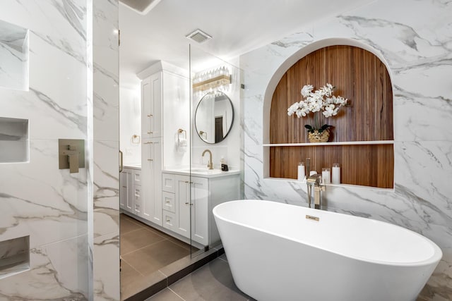 bathroom with vanity, a bath, and tile walls