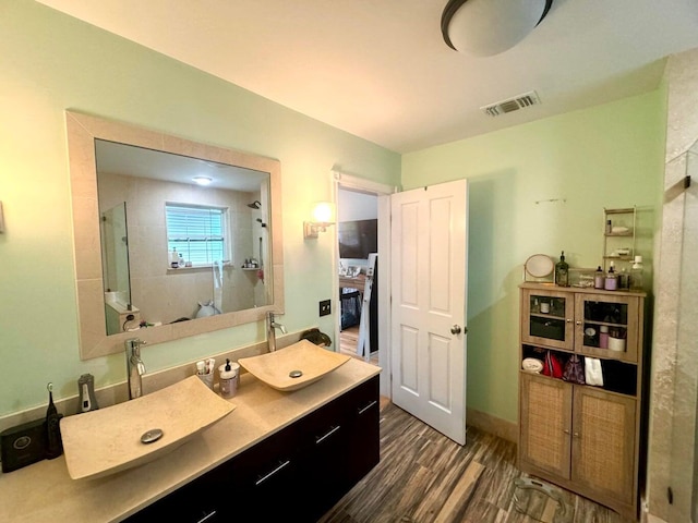 bathroom featuring vanity, wood-type flooring, and a shower