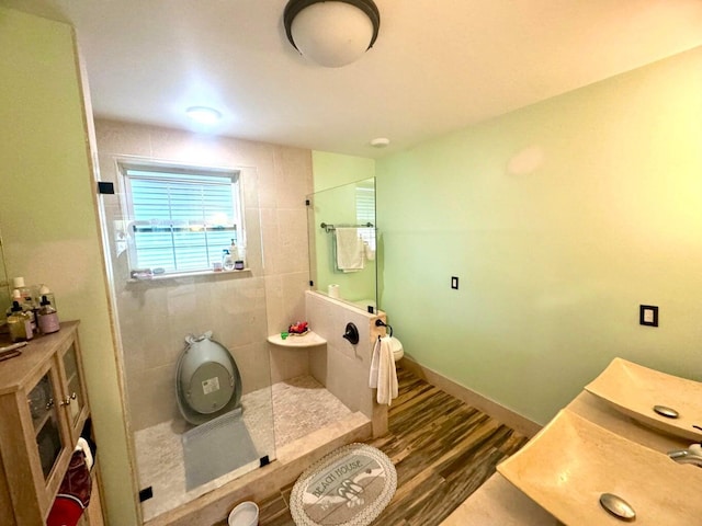 bathroom with hardwood / wood-style flooring and a tile shower