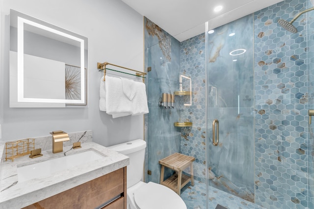 bathroom with toilet, a stall shower, and vanity