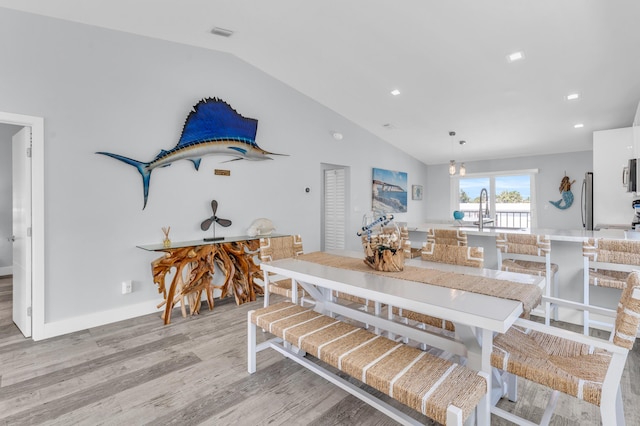 dining room featuring light wood-style flooring, visible vents, lofted ceiling, and recessed lighting