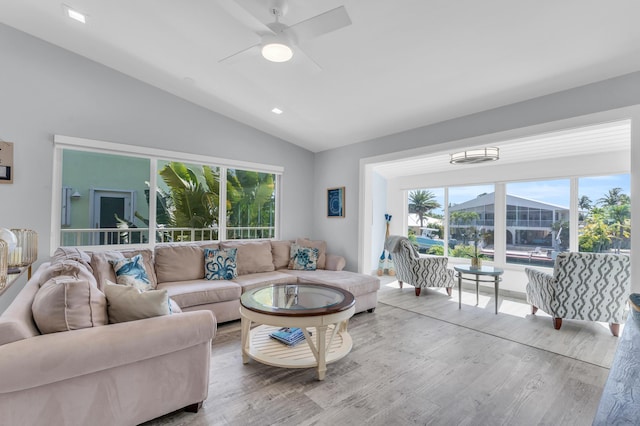 living area featuring a ceiling fan, plenty of natural light, wood finished floors, and lofted ceiling