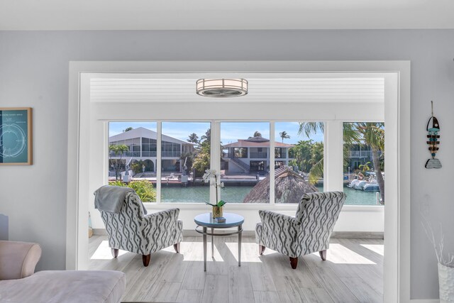 sitting room with a water view and wood finished floors