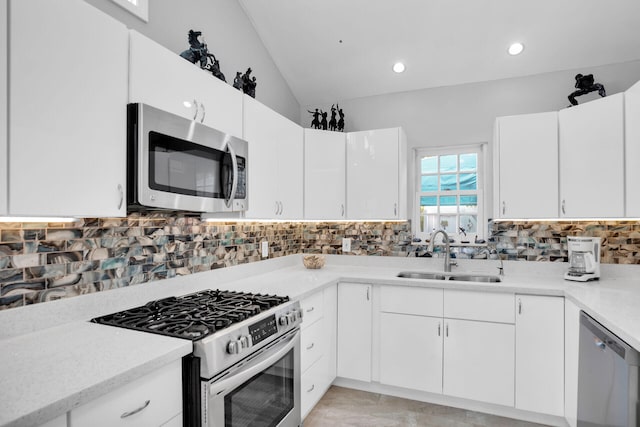 kitchen featuring tasteful backsplash, white cabinetry, appliances with stainless steel finishes, and sink