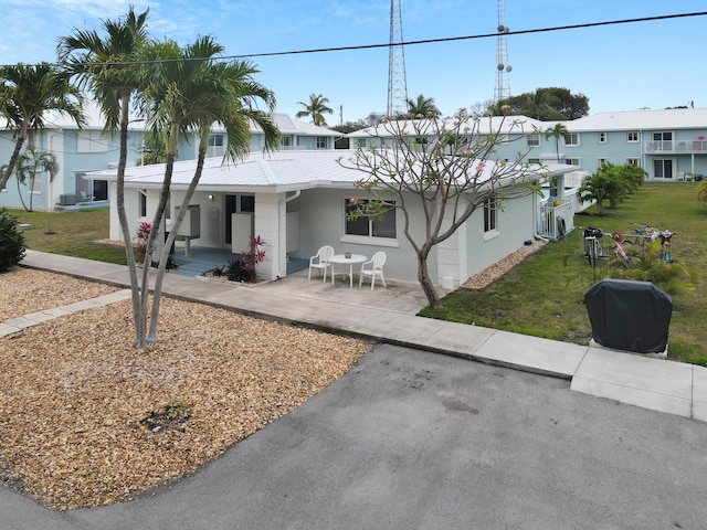 40 High Point Rd Unit C105, Tavernier, FL 33070 - view of front of property featuring stucco siding, covered porch, a front lawn, and metal roof