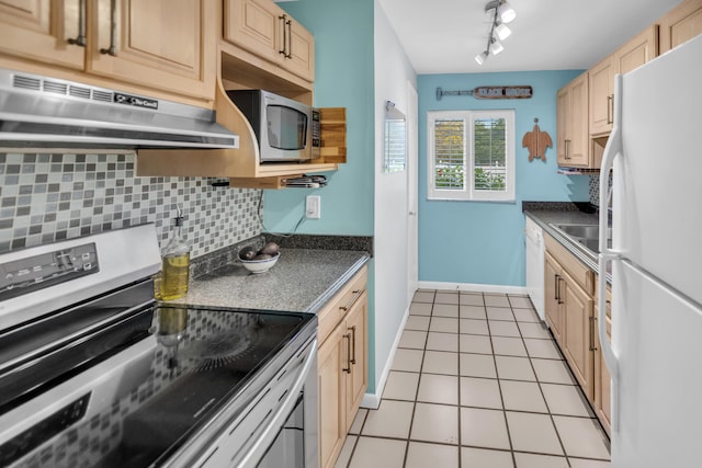 40 High Point Rd Unit C105, Tavernier, FL 33070 - kitchen with stainless steel appliances, under cabinet range hood, track lighting, tasteful backsplash, and dark countertops
