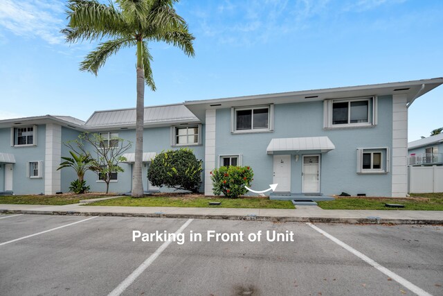 40 High Point Rd Unit C105, Tavernier, FL 33070 - view of property with uncovered parking, stucco siding, and metal roof