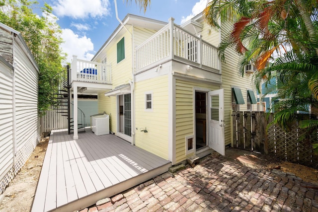 back of property with fence and a balcony