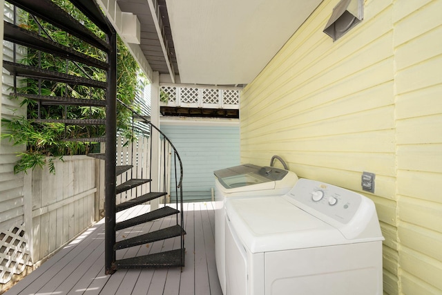 laundry area with wooden walls, laundry area, independent washer and dryer, and wood finished floors