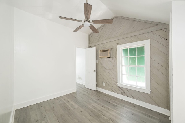 unfurnished room with wooden walls, baseboards, wood finished floors, lofted ceiling, and a wall mounted AC