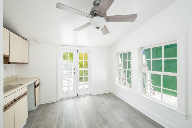 kitchen featuring light wood-style floors, baseboards, light countertops, french doors, and vaulted ceiling