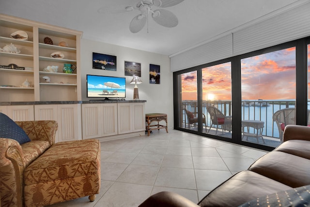 living area with ceiling fan and light tile patterned flooring