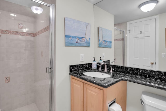 bathroom featuring vanity, an enclosed shower, and toilet