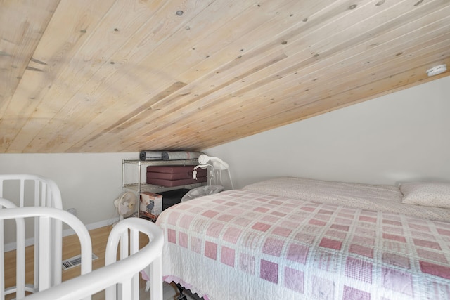 bedroom with vaulted ceiling, wooden ceiling, wood finished floors, and baseboards