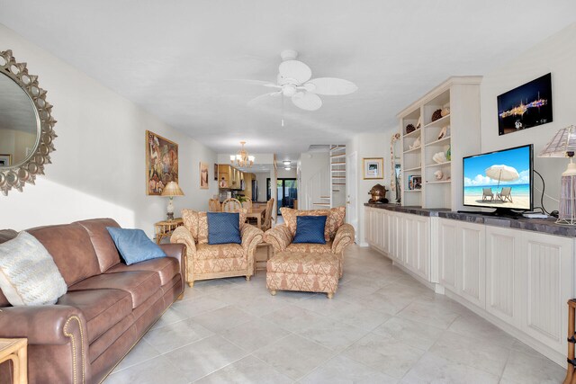 living room featuring stairs and ceiling fan with notable chandelier