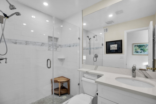 bathroom with a stall shower, visible vents, toilet, vanity, and recessed lighting