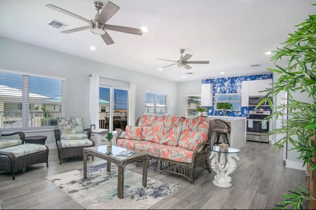 living room featuring ceiling fan and light wood-type flooring