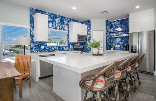 kitchen featuring a kitchen breakfast bar, stainless steel appliances, and a center island