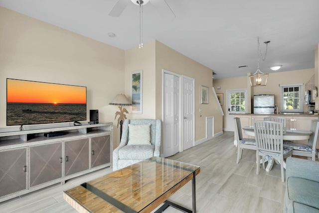 living area featuring ceiling fan and baseboards