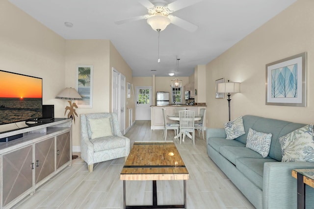 living room with ceiling fan, wood finish floors, and baseboards