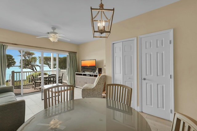 dining area featuring light tile patterned floors and ceiling fan with notable chandelier