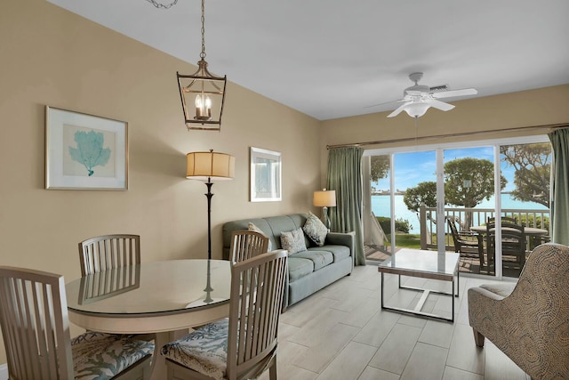 dining room with a water view and a ceiling fan