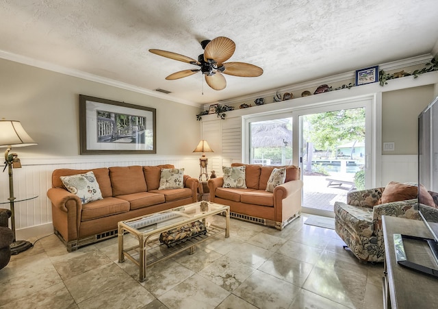 living room with crown molding, ceiling fan, and a textured ceiling