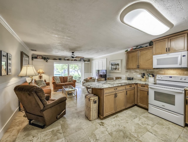 kitchen featuring crown molding, white appliances, light stone countertops, and kitchen peninsula