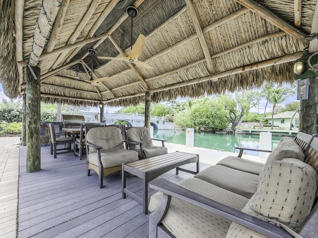 wooden deck featuring a gazebo, a water view, a grill, and ceiling fan