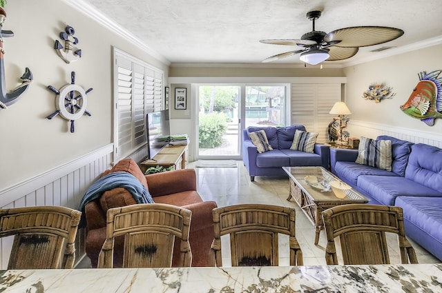 living room with light tile patterned flooring, crown molding, ceiling fan, and a textured ceiling