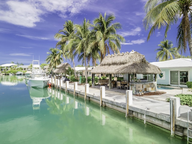 view of dock featuring a water view, exterior bar, and a gazebo