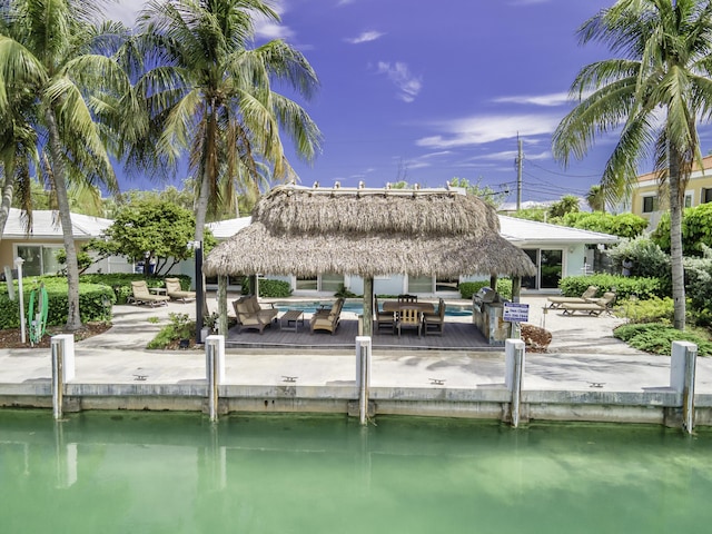 view of dock with a swimming pool, a patio, and a water view